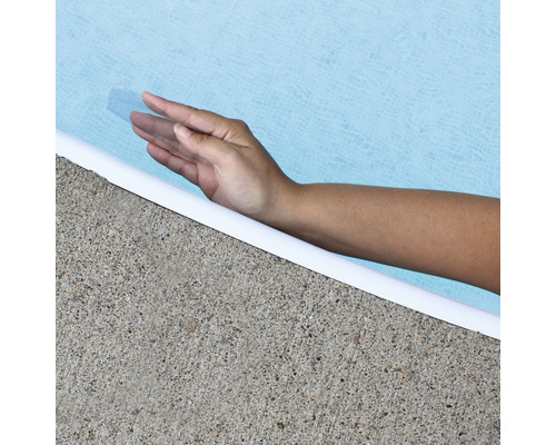 Hand berührt Poolwasser am Beckenrand