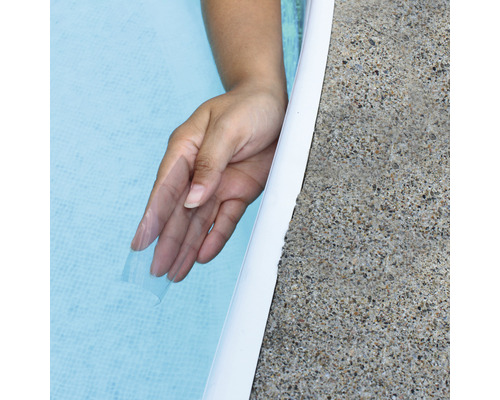 Hand im Poolwasser neben Beckenrand