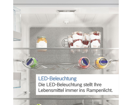 Innenraum eines Kühlschranks mit LED Beleuchtung, Regalen und Lebensmitteln.
