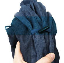 Blaues Stoffpaket mit Verschluss in der Hand