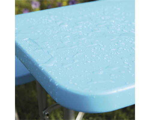 Detailansicht einer hellblauen Picknicktischplatte mit Wassertropfen