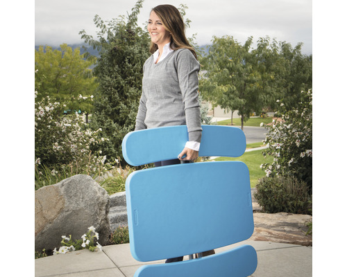 Frau trägt einen blauen, zusammenklappbaren Gartentisch