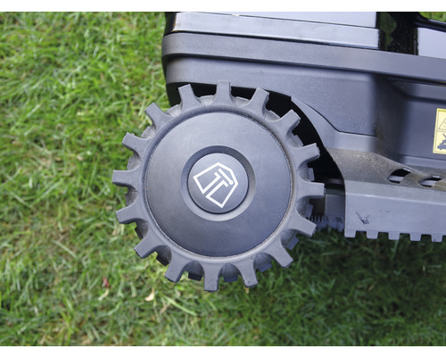 Detailaufnahme eines Rades eines Rasenmähroboters auf Gras