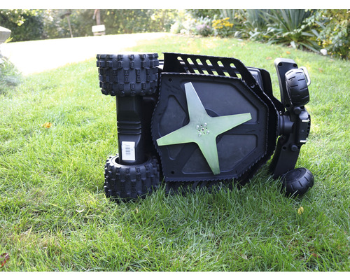 Umgedrehter Rasenmäher mit freiliegendem Mähwerk auf Rasen