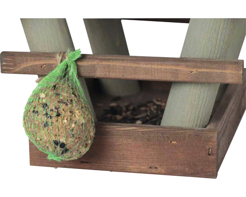 Vogelfutterknödel in einem grünen Netz an einem hölzernen Vogelhaus