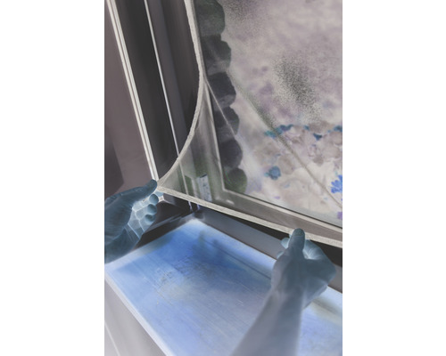 Person befestigt Insektenschutzgitter am Fenster