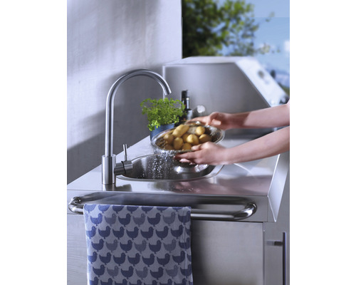 Person wäscht Kartoffeln am Edelstahlspültisch mit Handtuchhalter