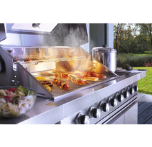 Edelstahl Grill mit Speisen auf dem Grillrost und Zubehör