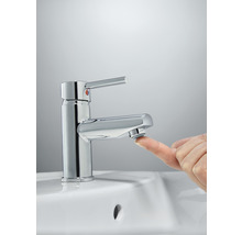Chromfarbene Waschtischarmatur mit Finger auf dem Perlator
