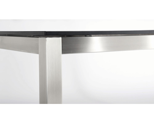 Detailansicht eines Tisches mit Metallgestell und Glasplatte