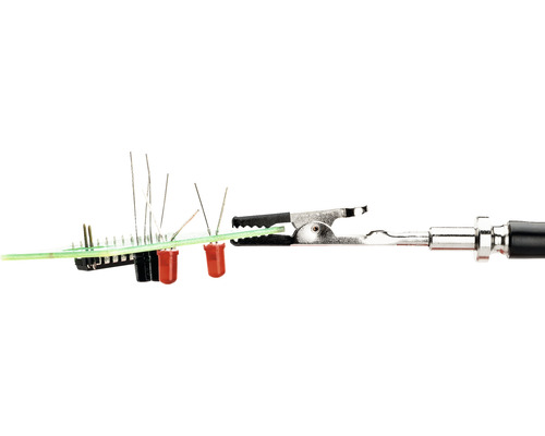 Elektronische Bauelemente auf einer Platine mit Krokodilklemme.