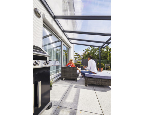 Überdachte Terrasse mit Grill, Sitzmöbeln und zwei Personen