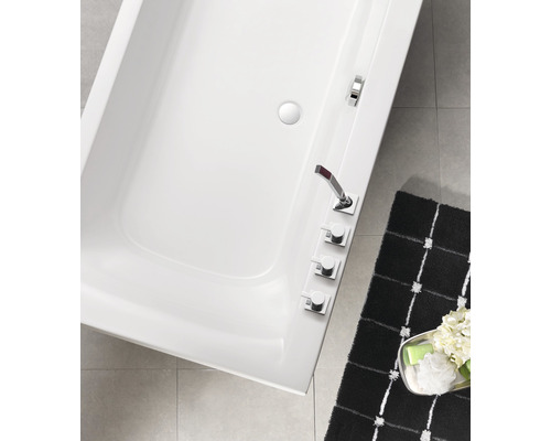 Aufnahme von oben einer weißen Badewanne mit Armaturen und einer Badematte