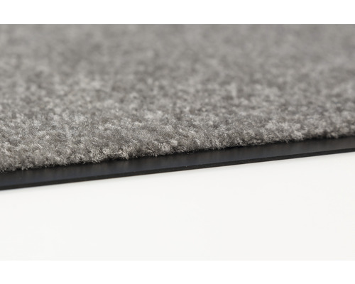 Detailansicht einer grauen Fußmatte mit Gummirand