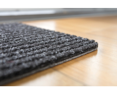 Graue Fußmatte mit Noppenstruktur auf hellem Holzboden