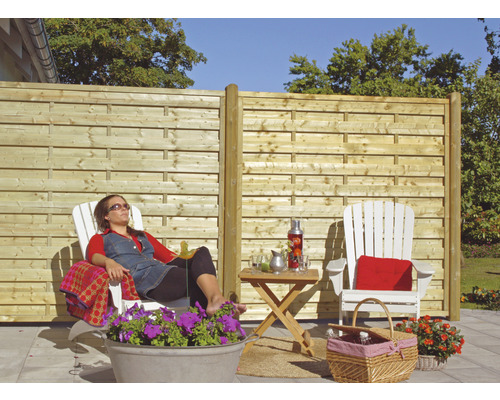 Szene im Garten mit Holzzaun, Gartenmöbeln und entspannter Person