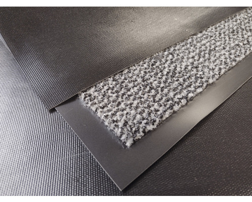 Detailansicht einer Fußmatte mit Textiloberfläche und einer Umrandung aus Metall