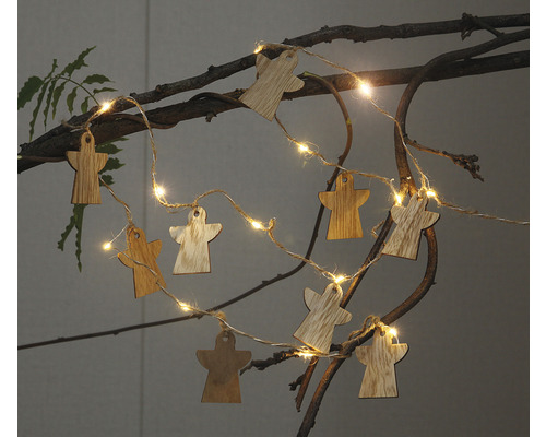 Lichterkette mit Holzanhängern in Engelform auf einem Ast
