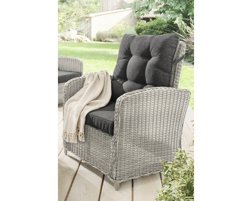 Grauer Rattansessel mit grauen Kissen und Decke im Garten