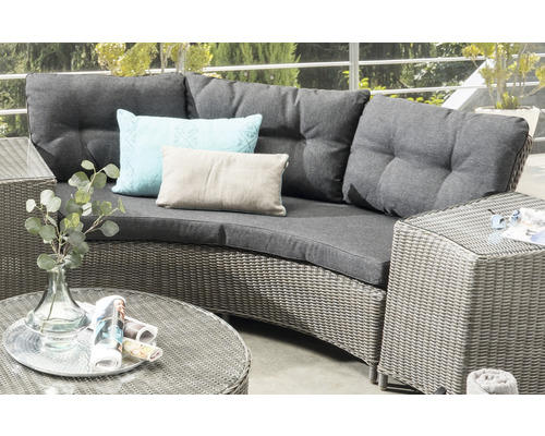 Gartenlounge-Set mit Rattanoberfläche, grauen Polstern und Kissen auf einer Terrasse