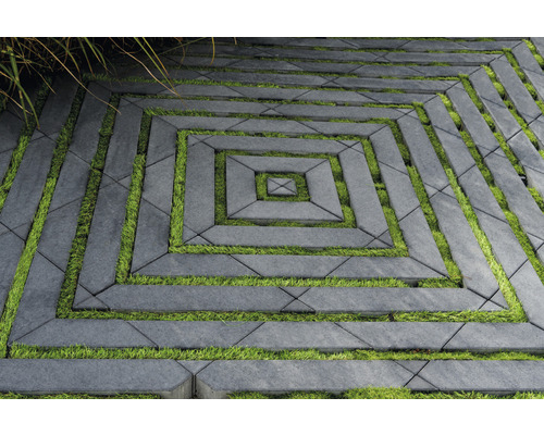 Quadratisches Muster aus grauen Pflastersteinen mit Gras in den Zwischenräumen