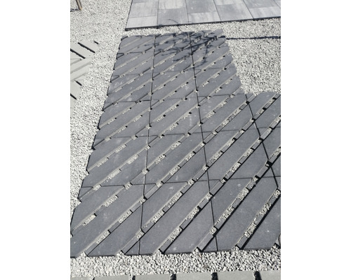 Verlegung von Rasengittersteinen auf Kiesfläche für Gartenweg.