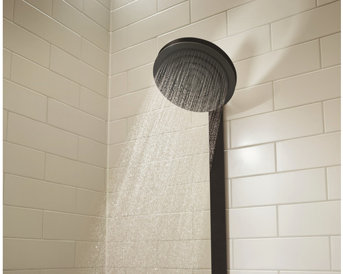 Brausekopf mit Wasserstrahl vor gefliester Wand