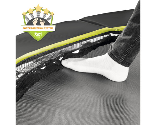 Detailaufnahme eines Trampolins mit Fußschutzsystem und dem Fuß einer Person