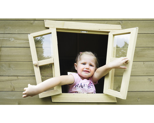 Mädchen öffnet Fenster eines Holzspielhauses