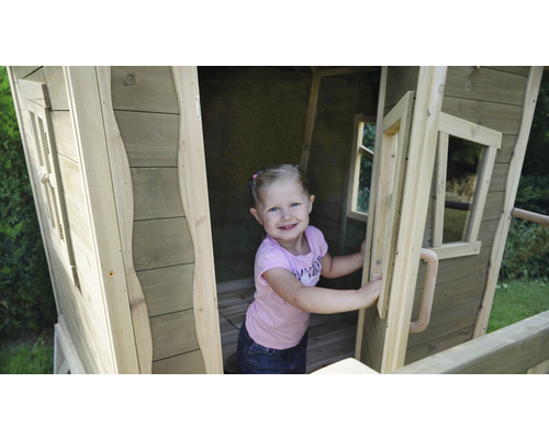 Mädchen in einem Holzspielhaus im Garten