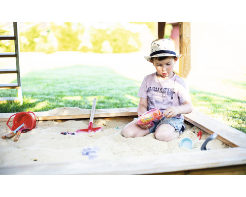 Junge spielt mit Spielzeug im Sandkasten