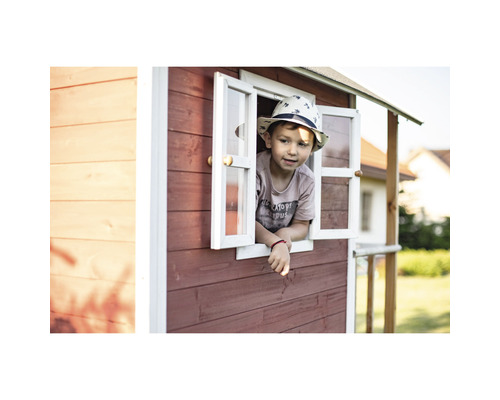 Ein Kind schaut aus dem Fenster eines Spielhauses