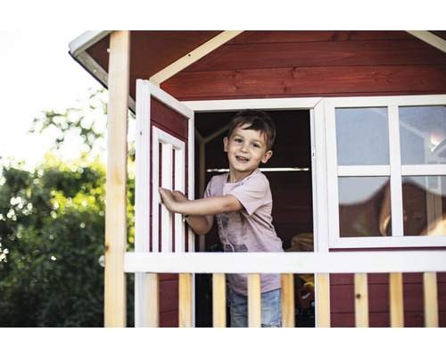 Junge im Holzspielhaus mit Fenster und Tür