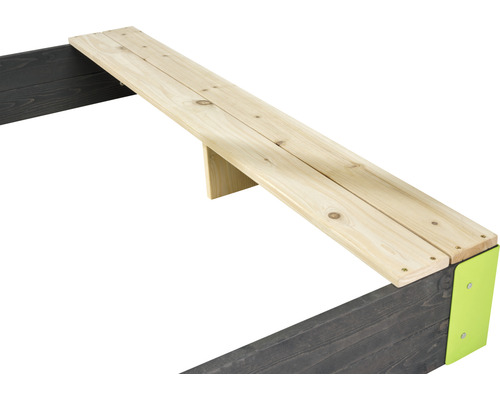 Detailansicht einer Sandkiste mit Holzbank und Metallecken