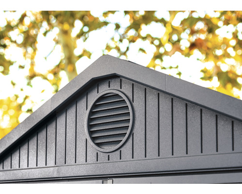 Detailaufnahme einer Gartenhausfassade mit runder Lüftungsöffnung.