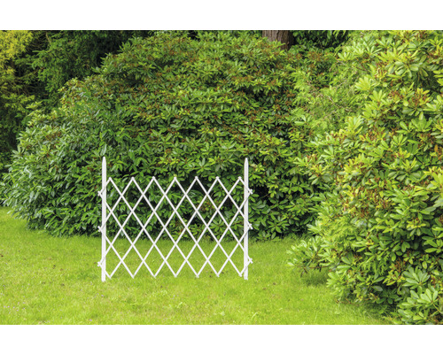 Ausziehbarer, weißer Gartenzaun aus Holz im Garten