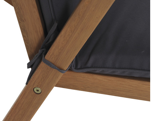 Detailaufnahme eines Holzstuhls mit dunklem Kissen, befestigt mit Stoffbändern