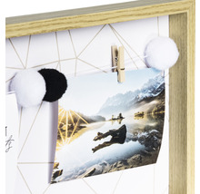 Dekoratives Memoboard mit Fotos und Büroklammern in hellem Holzrahmen