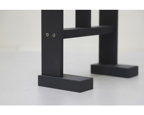 Detailansicht eines schwarzen Holzmöbelstücks, befestigt mit Schrauben.