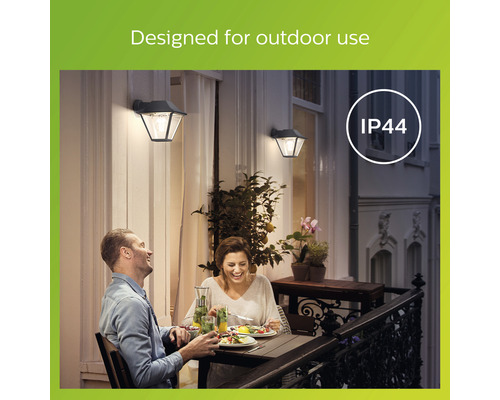 Szene mit zwei Personen beim Abendessen im Freien und zwei Außenwandleuchten mit der Schutzart IP44.