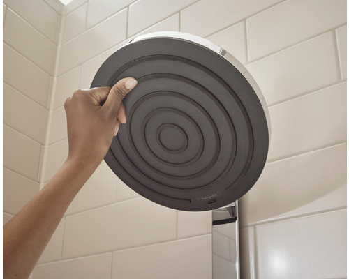 Person hält Duschkopf im Badezimmer.