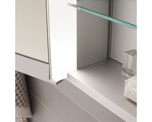 Detailansicht eines Badezimmerschranks mit Glasablage und Handtuch