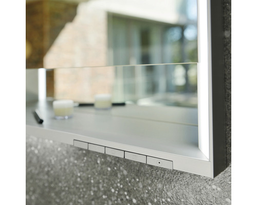 Detailansicht eines Spiegelschranks mit Ablagefläche und Bedienknöpfen