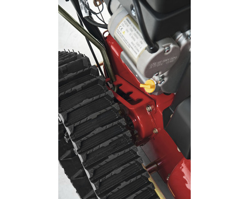 Detailansicht einer Schneefräse mit Raupenantrieb und Motor.