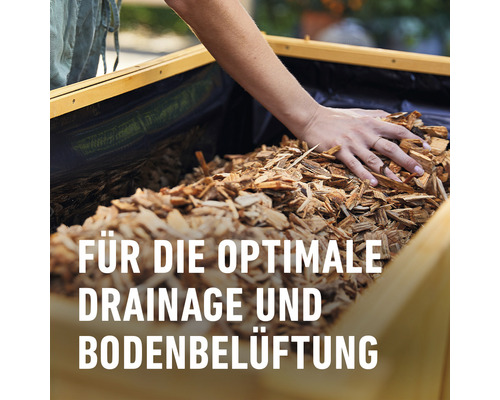 Holzhackschnitzel in einem Hochbeet für optimale Drainage und Bodenbelüftung