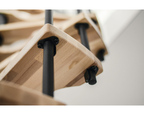 Detailaufnahme einer Holztreppe mit schwarzen Metallelementen