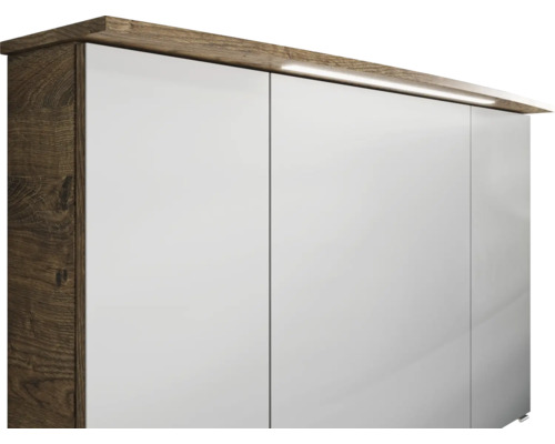 Detailansicht eines Schranks mit weißen Türen und Holzelementen inklusive Beleuchtung