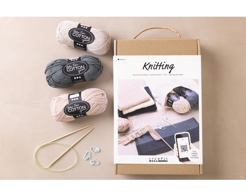 Strickset mit Baumwollgarn, Stricknadeln und Anleitung in einer Schachtel