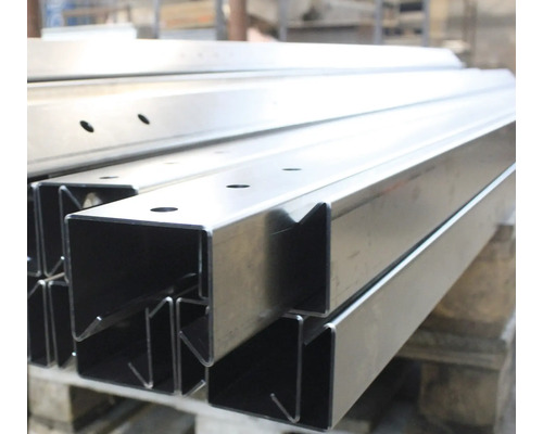 Stahlprofile mit Löchern auf einer Palette gestapelt.