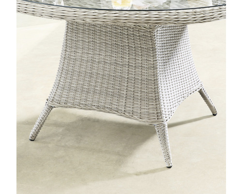 Detailansicht eines Gartentisches mit Glasplatte und geflochtenem Untergestell.